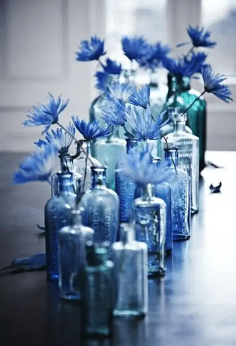 cornflower arrangement in glass bottles